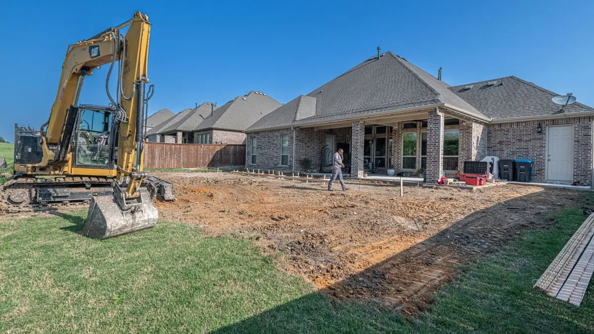 Backyard regraded for drainage behind a brick home in Prosper TX